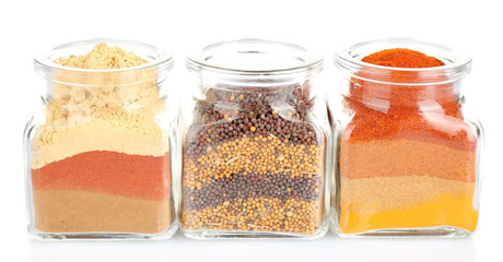 Different kinds of spices in glass bottles isolated on white