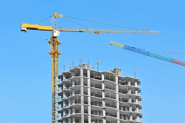 Crane and building construction site against blue sky