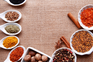 Different kinds of spices in ceramics bowls and spoons