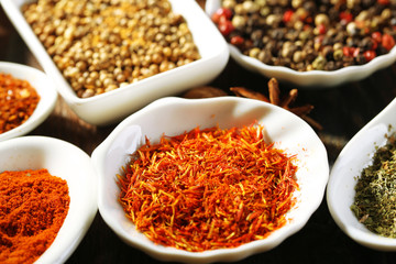 Different kinds of spices in ceramics spoons, close-up,