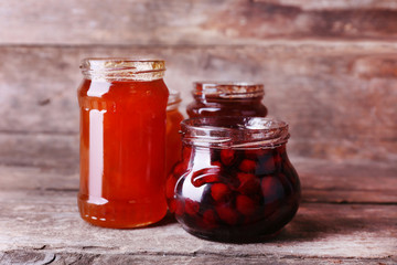 Homemade jars of fruits jam on rustic wooden background