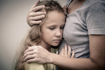 portrait of one sad daughter hugging his mother