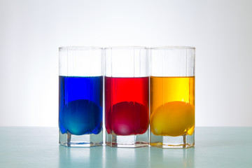 painted Easter eggs in red yellow blue color liquid