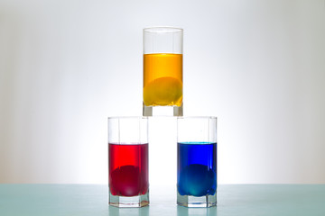 three colorful cups with eggs in the form of a pyramid