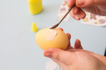 woman paste  image on   colored egg with  brush