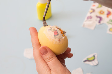 woman paste  image on  egg with  brush