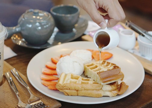 Pouring syrub into the waffle