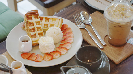 Waffle serving with ice cream and strawberry