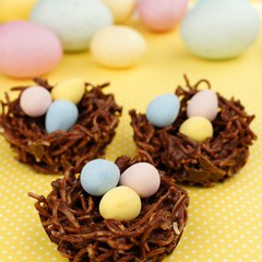 Springtime chocolate nests filled with Easter eggs on yellow