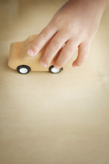 木製の車のおもちゃで遊ぶ子供の手