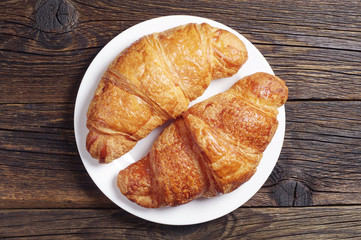 Two tasty croissants in white plate
