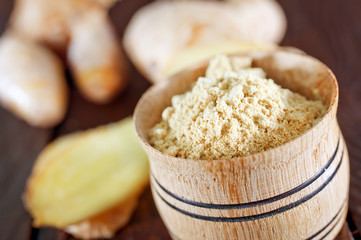 dry ginger in the wooden bowl and on a table