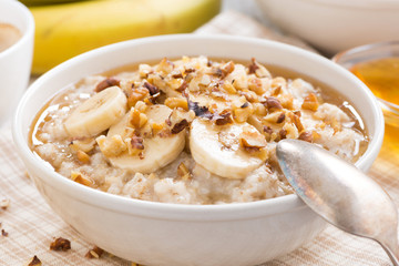 oatmeal with banana, honey and walnuts in bowl for breakfast