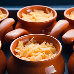 Roast with vegetables, meat and cheese in pottery.