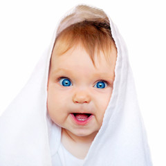 Surprised baby under the white towel