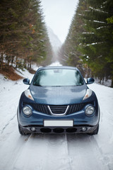 Obraz na płótnie Canvas Blue car on snowy road, wintertime