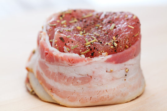 Steak with bacon and spices prepared for grilling.