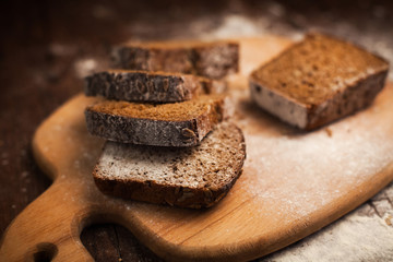 Sliced rye bread on cutting board closeup on table
