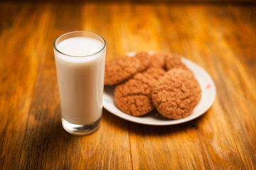 Oatmeal cookies and glass of milk on napkin on table