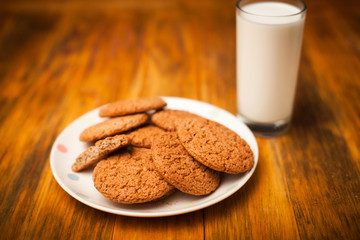 Oatmeal cookies and glass of milk on napkin on table