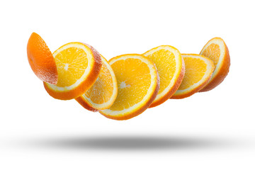 Falling slices of orange in air on white