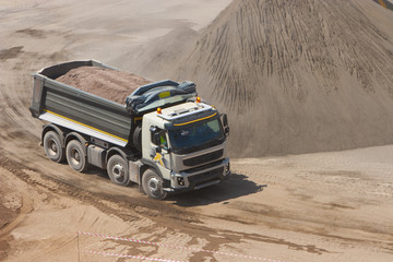 Truck and bulldozer work in the quarry