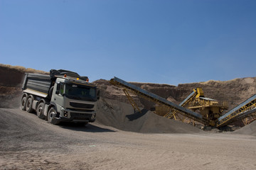 Truck and bulldozer work in the quarry
