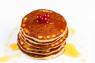 Pancakes with honey and cranberries on a plate.