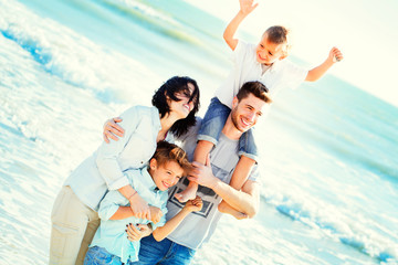 family having walking on the beach to the sea