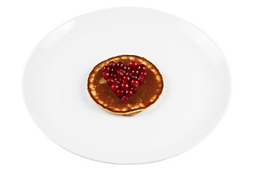 Fried pancakes with cranberry heart shaped with honey on a plate