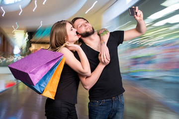 Happy couple with shopping bags taking selfie