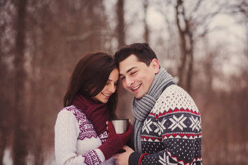 Fototapeta premium young couple smiling and drinking tea in the forest