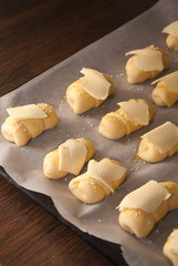 Mini croissants with cheese and sesame seeds ready for baking