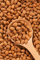 Almond background with large spoon full with fruits