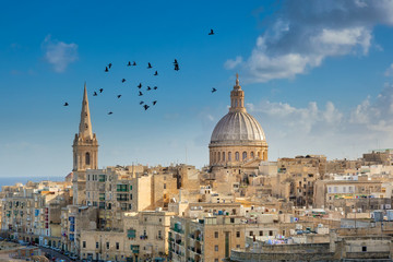 Fototapeta na wymiar Valetta city buildings with birds flying