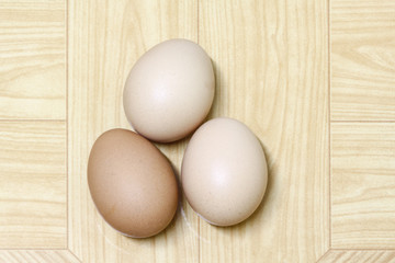 three eggs isolated on brown background