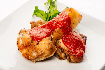 Roasted pork ribs with tomato sauce, parsley and spices laying o