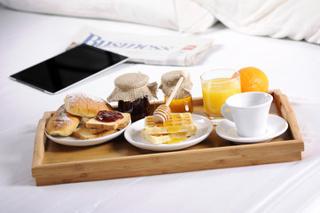 Tray with breakfast on a bed in a hotel room