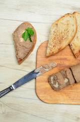 Roll pate, slices of toasted bread, wooden background. Top view.
