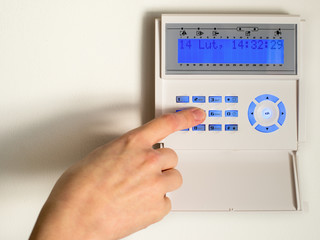 pressing the code on a house alarm