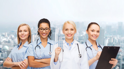 smiling female doctor and nurses with stethoscope