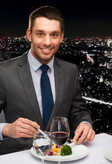smiling man eating main course