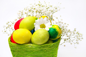 colorful easter eggs and a basket with flowers