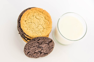 chocolate and sugar cookies stacked with glass of milk