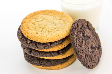 chocolate and sugar cookies stacked with glass of milk