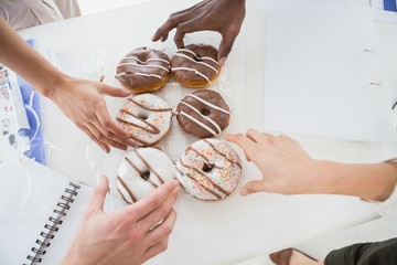 Business people taking doughnut at desk