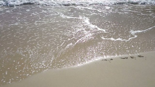 Wort TRAUMREISEN im Sand wird von Wellen weggesp&uuml;lt