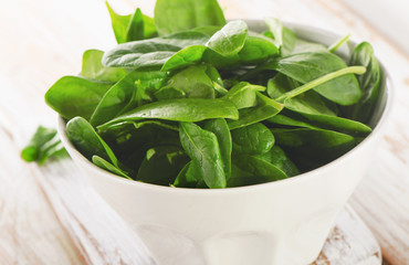 Fresh spinach leaves in white bowl