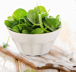 Spinach leaves in white bowl.