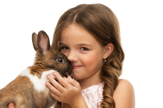 Little girl kissing cute brown bunny